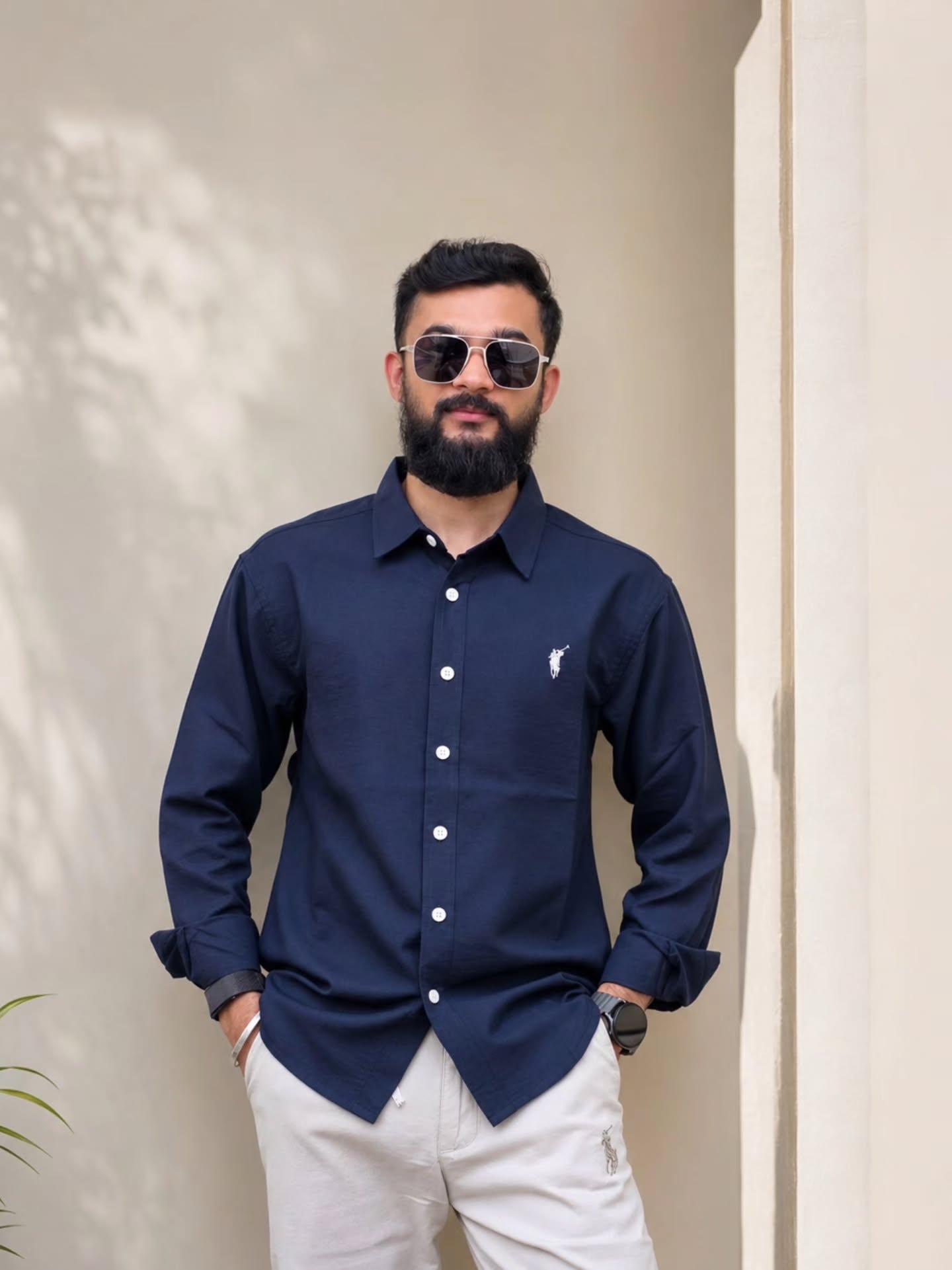 Navy long-sleeve shirt with cream trousers