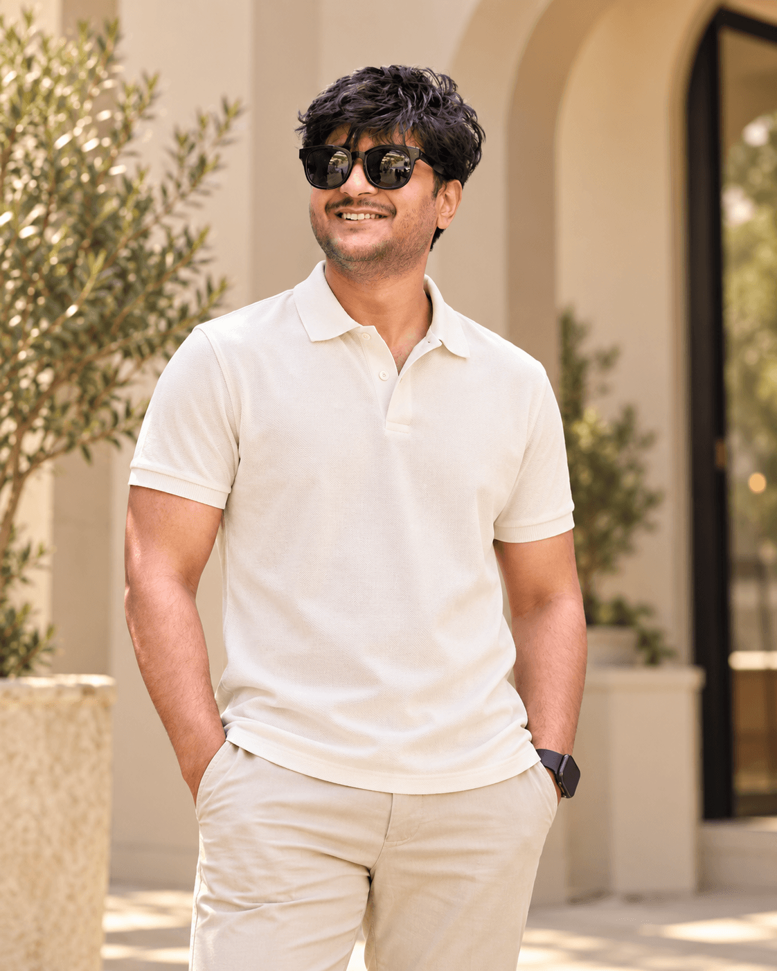 Dipesh wearing a cream polo and light trousers