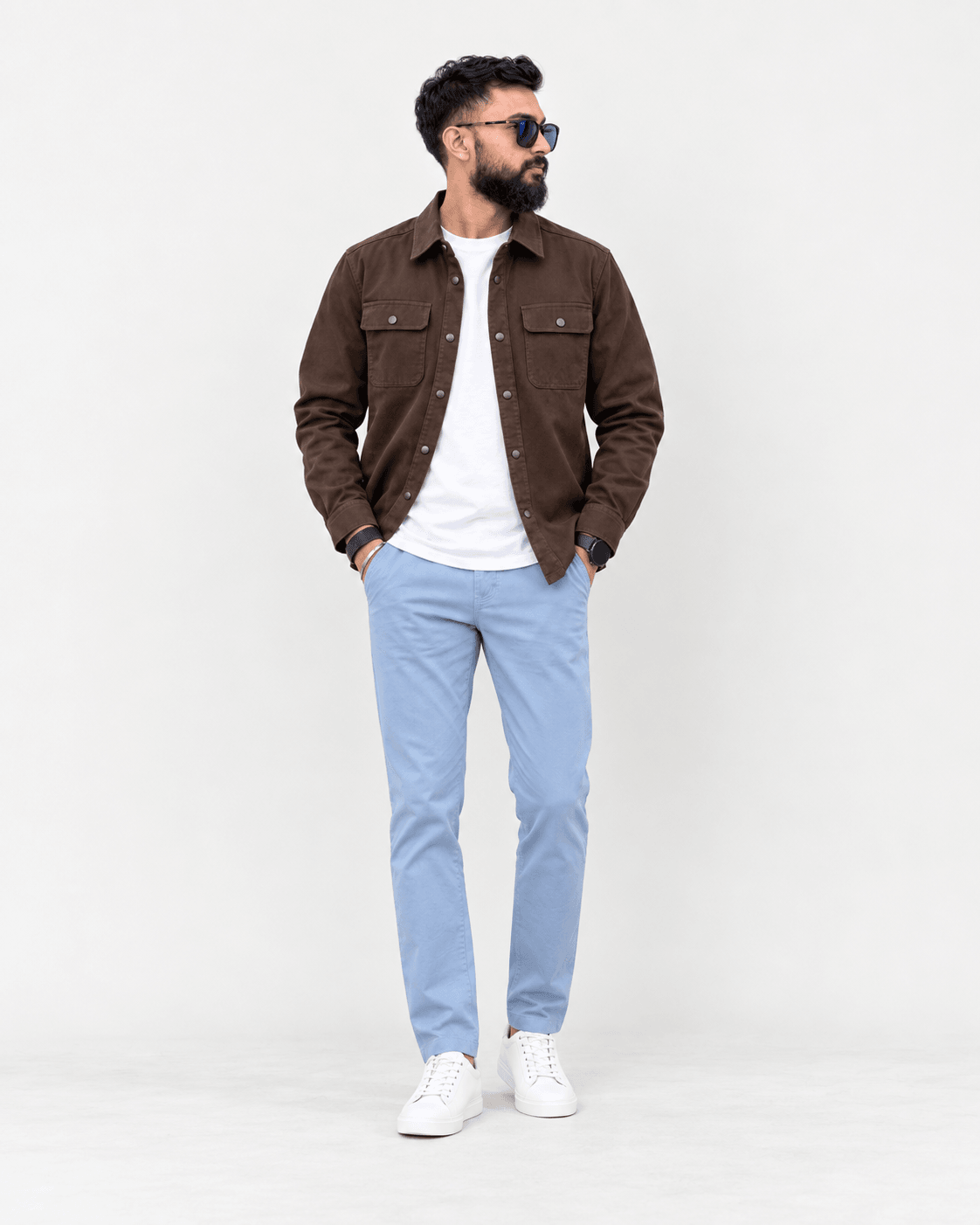 Rajnish wearing a brown overshirt, white T-shirt, and light blue trousers
