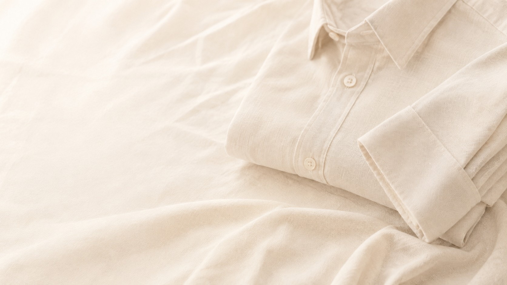 Natural linen shirt folded on softly draped fabric